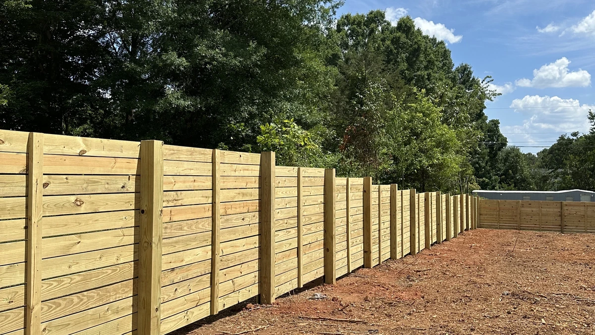 A new pressure treated privacy fence running the length of a back yard in Mooresville